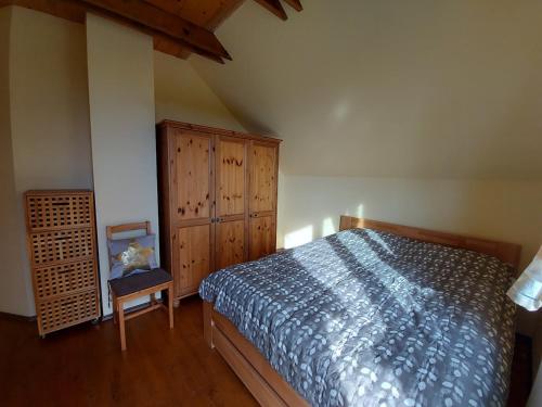 a bedroom with a bed and a wooden cabinet at Chalet Červená Veža in Banka