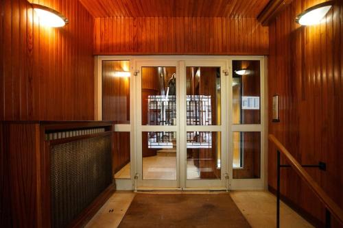 - une porte dans une chambre dotée de murs en bois dans l'établissement Charmant studio Paris 16ème MICHEL ANGE - 34m2, à Paris