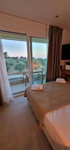 a bedroom with a bed and a large window at IVANKA'S VILLAS in Skala Rachoniou