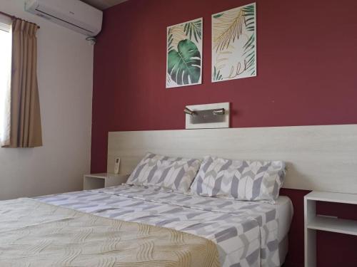 a bedroom with a bed and a red wall at Destino Termal in Federación