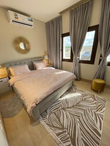 a bedroom with a large bed and a rug at Hawana Salalah Poolside Apartment in Salalah