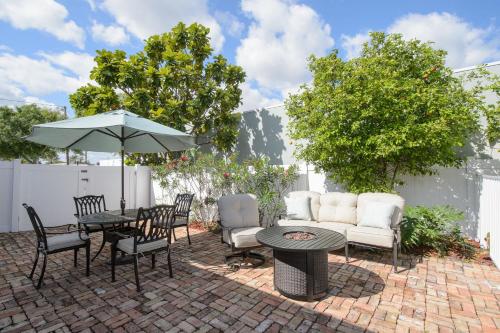 a patio with a table and chairs and an umbrella at Old Colorado Inn in Stuart