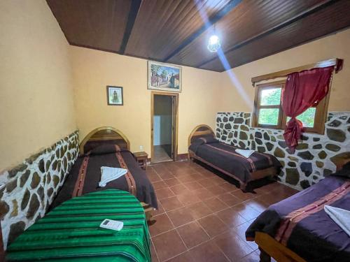 a living room with two beds and a window at El Retiro Lanquin in Lanquín