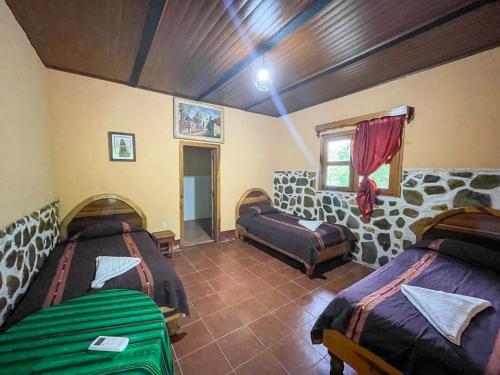 a room with two beds and a window at El Retiro Lanquin in Lanquín