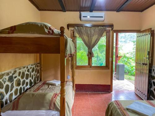 a bedroom with a bunk bed and a window at El Retiro Lanquin in Lanquín