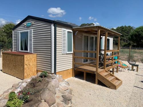 une petite cabine avec une terrasse couverte et une terrasse dans l'établissement Mobil- home à Calenzana, à Calenzana