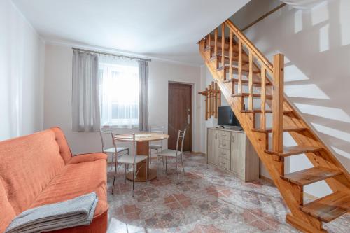 a living room with a staircase and a table at Pensjonat Jagódka in Trzęsacz