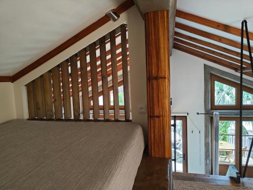 una camera da letto con un letto e una grande finestra di Casca de Noz - Modern Rustic Beach Getaway ad Angra do Heroísmo
