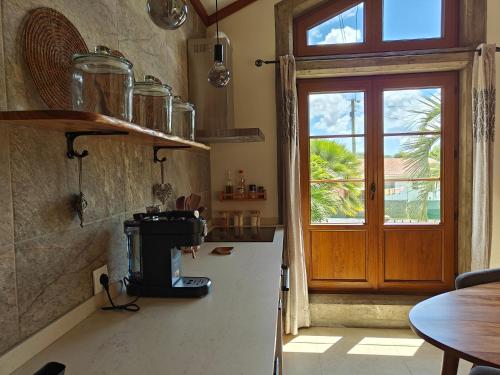 a kitchen with a counter with a stove and a window at Casca de Noz - Modern Rustic Beach Getaway in Angra do Heroísmo