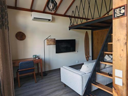 a room with a loft bed with a chair and a desk at Casca de Noz - Modern Rustic Beach Getaway in Angra do Heroísmo