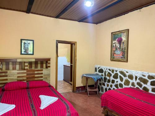 a bedroom with two beds and a mirror at El Retiro Lanquin in Lanquín