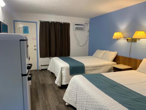 a hotel room with two beds and a window at Swiss Sunset Inn in Penticton