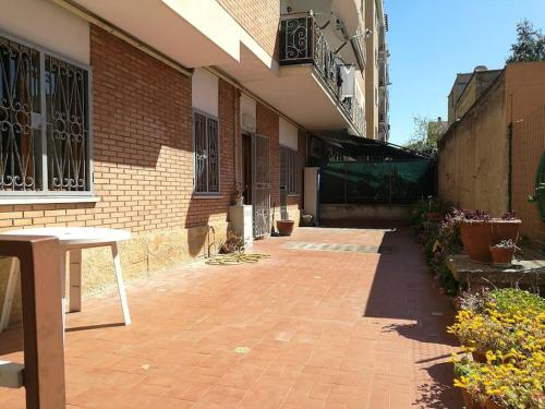 a brick patio with a table and a building at Sole ampi spazi quiete John apartaments in Ciampino