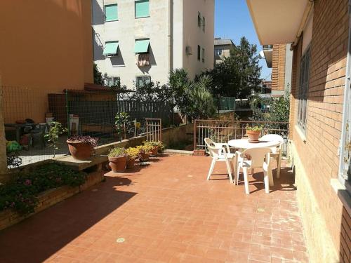 a patio with a table and chairs and a building at Sole ampi spazi quiete John apartaments in Ciampino