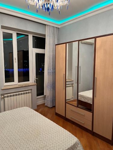 a bedroom with a bed and a dresser and windows at Sea view couple apartmant at boulvard,near nizami street in Baku