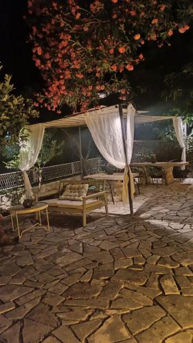 a patio with benches and a canopy with flowers at Serenita Stone House in Becici