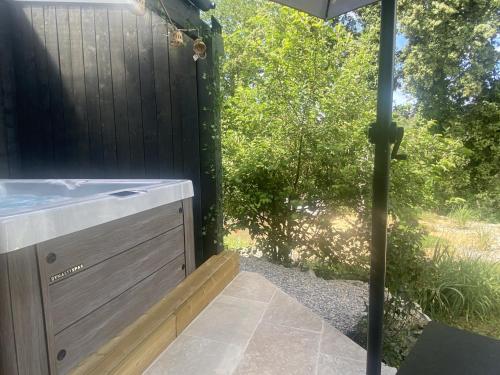 a backyard shower with a sink and an umbrella at La chambre d'hôte de la fontaine de Jonquier Jacuzzi privatif in Séguret