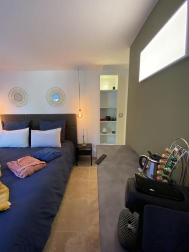 - une chambre avec un grand lit bleu et une fenêtre dans l'établissement La chambre d'hôte de la fontaine de Jonquier Jacuzzi privatif, à Séguret