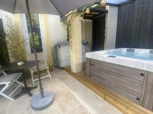 La salle de bains est pourvue d'une baignoire avec un parasol. dans l'établissement La chambre d'hôte de la fontaine de Jonquier Jacuzzi privatif, à Séguret