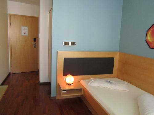 a bedroom with a bed with a candle on a table at Businesshotel Valerian in Hohenems