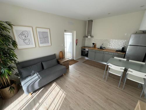 a living room with a couch and a kitchen at 180 Guest Suite in Ovar