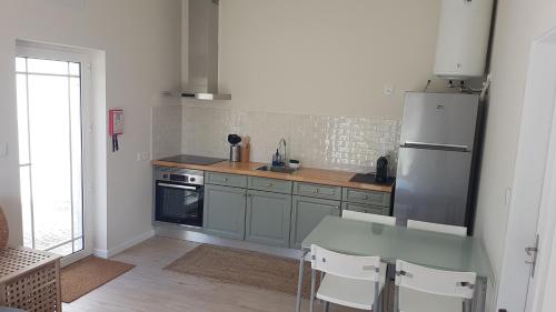 a kitchen with a refrigerator and a table and chairs at 180 Guest Suite in Ovar