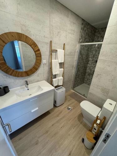 a bathroom with a sink and a toilet and a mirror at 180 Guest Suite in Ovar