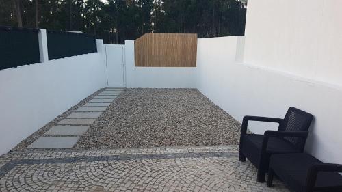 a room with a white wall and a chair at 180 Guest Suite in Ovar