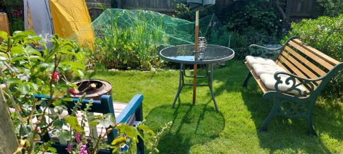 a garden with a table and a bench and some plants at Felixstowe room lets in Felixstowe