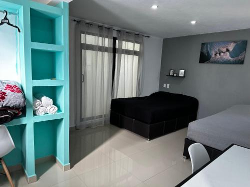 a bedroom with a black bed and a blue shelf at HOTEL NUEVA LUNA in Zacatlán