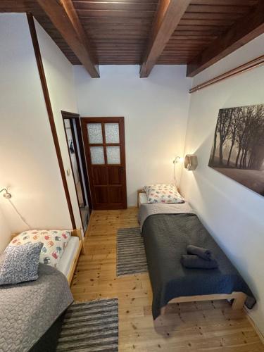 two twin beds in a room with a door at Harmony & Wine Eger in Eger