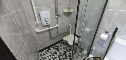 a bathroom with a shower with a phone on the wall at Rose Homestay Brighton - Free parking Ensuite studio room near Brighton Uni in Brighton & Hove