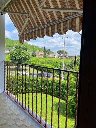 a balcony with a view of a green yard at Bollicine&Relax in Col San Martino