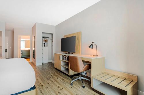 a bedroom with a desk with a computer and a bed at EVEN Hotel Waco - University Area by IHG in Waco