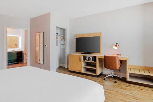 a bedroom with a bed and a desk with a television at EVEN Hotel Waco - University Area by IHG in Waco