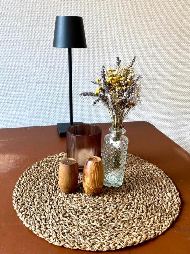 a table with a vase of flowers and two candles at Tiny House Zur Alten Sparkasse in Groß Garz