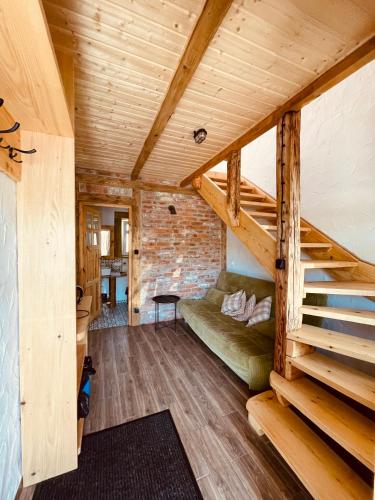 a living room with a green couch and stairs at MOTOMYCZKI-motel in Myczkowce