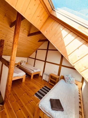 an attic room with two beds and a window at MOTOMYCZKI-motel in Myczkowce