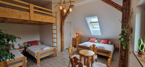 a bedroom with two bunk beds and a table and chairs at Derkaczowa Kotlina in Gniewoszów