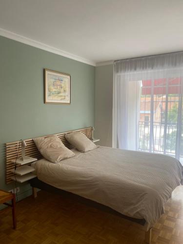 une chambre avec un grand lit avec une fenêtre dans l'établissement Arcachon, à Arcachon