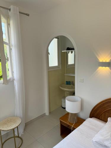 - une chambre avec un lit et une salle de bains avec un miroir dans l'établissement VILLA 4 Étoiles, MOANA , mer à 50 m ,été du Samedi au Samedi, à Saint-Peïre-sur-Mer