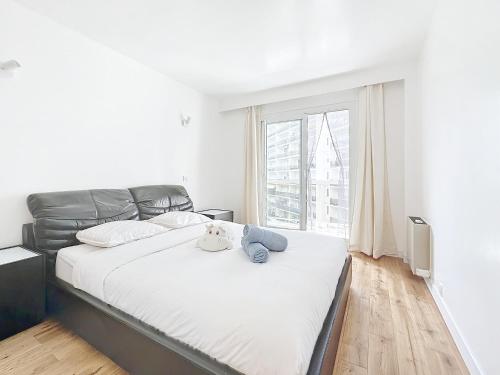 une chambre avec un grand lit et une grande fenêtre dans l'établissement 114 - Paris Appartement Rénové de Luxe pour 4 Personnes, à Paris