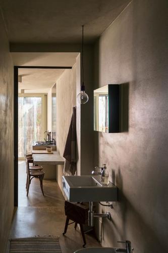 a bathroom with a sink and a table at Residenza Rosso Di Sera in Capoliveri