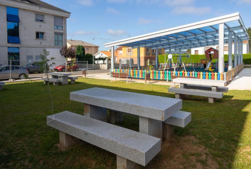 a group of benches in a park with a playground at Rest Pedrouzo in O Pedrouzo