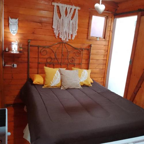 a bedroom with a bed in a log cabin at FINCA los nogales in General Belgrano