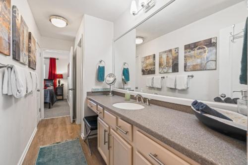 a bathroom with a sink and a large mirror at Heart of Downtown/Walk to BROADWAY & THE ACTION/BARS/Music Venues/Honky Tonks! in Nashville