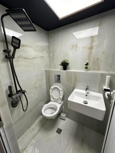 a bathroom with a toilet and a sink at Къща за гости Стил in Kiten