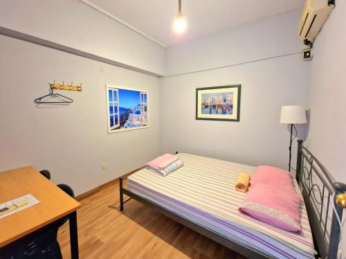 a small bedroom with a bed and a desk at SleepEasy in Athens