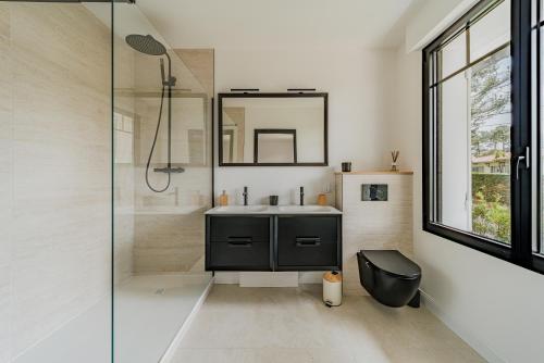 une salle de bain avec un lavabo et une douche en verre dans l'établissement Mon paradis, à La Teste-de-Buch