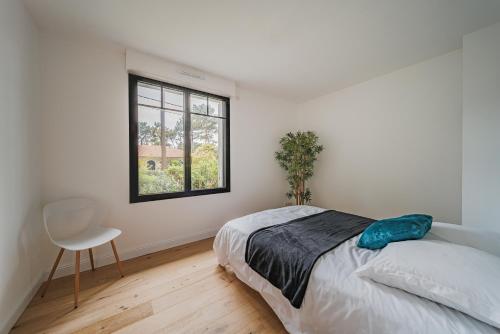 une chambre avec un lit, une fenêtre et une chaise dans l'établissement Mon paradis, à La Teste-de-Buch